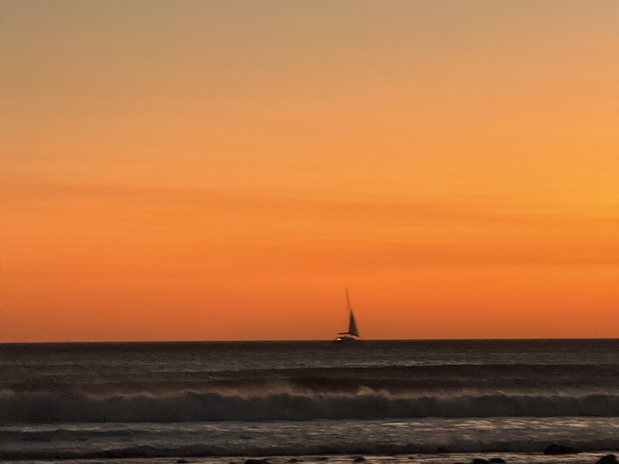 Orange sunset over the Pacific with a sailboat, El Salvador